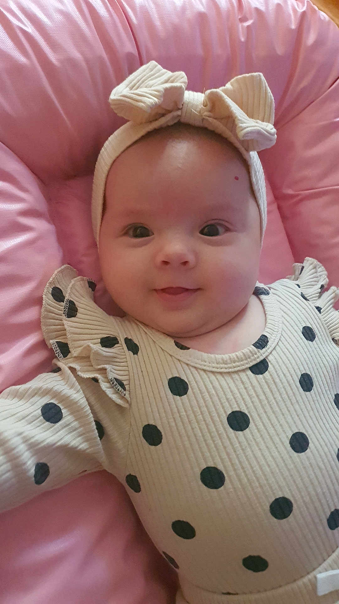 Luana participe au concours pour gagner de l'argent avec cette photo : baby, infant, smiling, headband, bow, polka_dot, clothing, pink, cushion, soft, portrait, child, cute, happy, closeup, face, indoors, person, rippled_texture, fashion