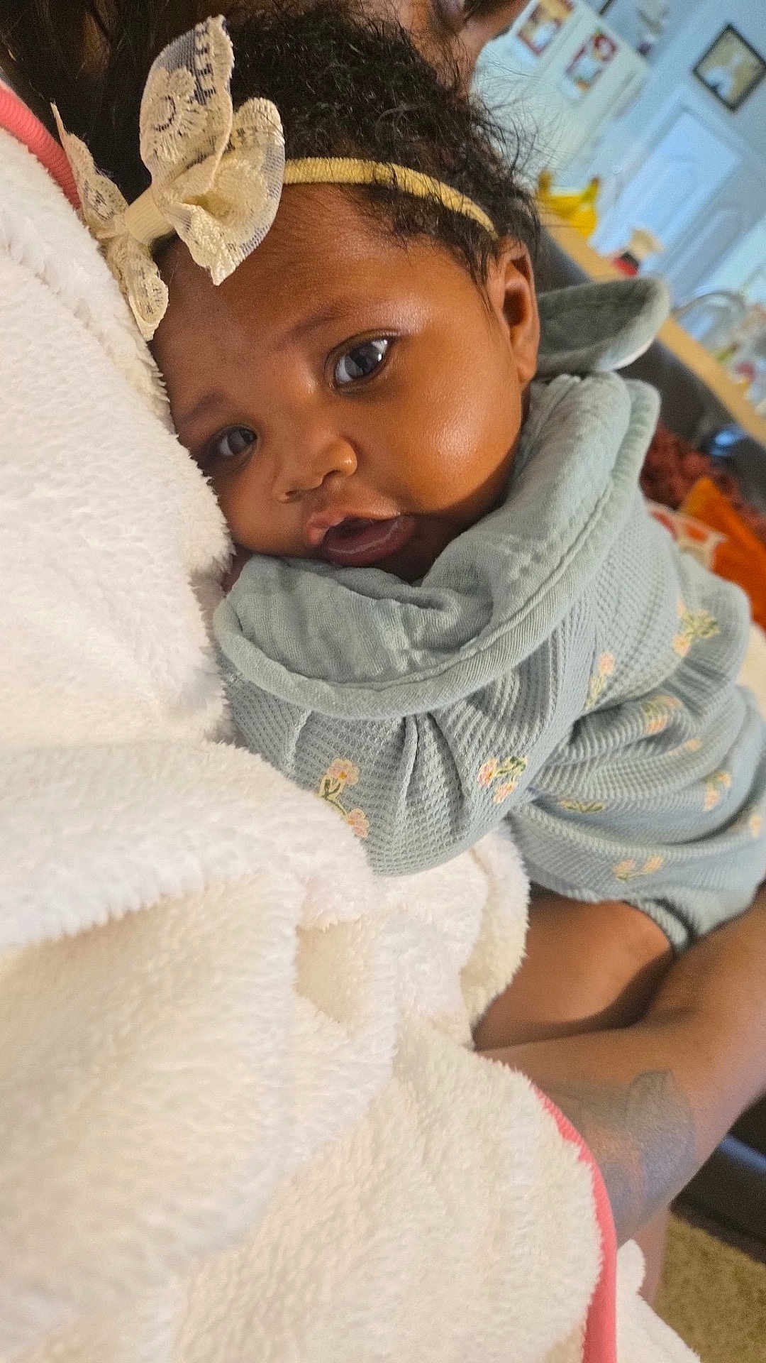 Kalynn King joined the competition — help win amazing prizes! baby, child, face, headband, bow, blanket, clothing, floral_pattern, couch, indoor, person, portrait, cute, snuggling, soft_texture, infant, warm, happy, skin, closeup