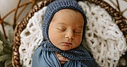Colter is registered to the contest to win money with this photo: newborn, baby, sleeping, swaddled, blue_bonnet, blue_wrap, basket, blanket, knit, cozy, infant, portrait, peaceful, resting, cute, soft_texture, warm_lighting, closeup, indoors, child
