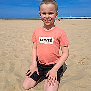 Sasha a rejoint le concours — aidez-le/la à gagner de superbes lots ! beach, blue_sky, boy, casual_clothing, child, daylight, happy, kneeling, levis, outdoor, person, pier, sand, shorts, sky, smiling, summer, sunny, tshirt, vacation