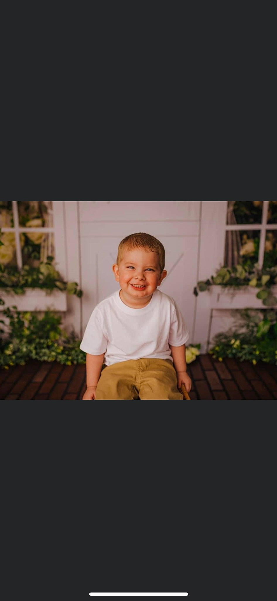 Hunter joined the competition — help win amazing prizes! face, flash_photography, flooring, fun, grass, happy, joy, person, photo_caption, plant, portrait, room, shirt, shorts, sitting, sleeve, smile, t_shirt, tints_and_shades, toddler