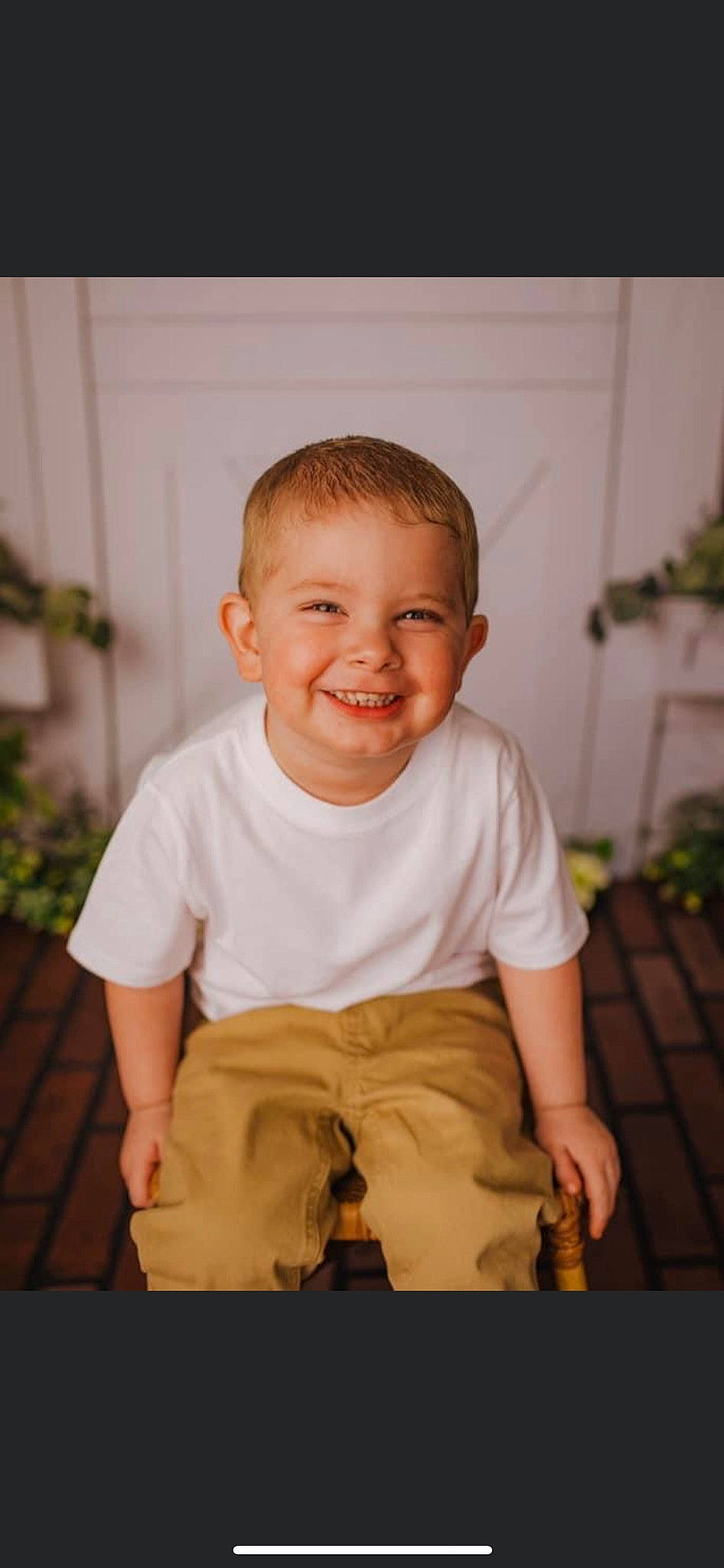 Hunter is registered to the contest to win money with this photo: arm, baby, baby_toddler_clothing, cheek, chin, eye, face, flash_photography, happy, head, human_body, joy, mouth, nose, person, plant, shorts, skin, sleeve, smile