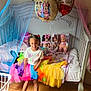 Egypt is registered to the contest to win money with this photo: balloons, bed, birthday, birthday_party, celebration, child, colorful_clothing, decorations, doll, girl, hair_braids, indoor, mickey_mouse, minnie_mouse, netting, pink_shoes, smiling, toys, tutu, wooden_floor