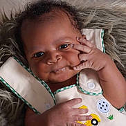 Mario joined the competition — help win amazing prizes! baby, infant, face, hand, smile, clothing, fur, cute, portrait, child, young, person, eyes, skin, button, fabric, cheek, expression, sitting, indoors