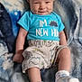 baby, infant, smile, dinosaur, clothing, socks, blanket, pattern, blue, cute, child, person, lying_down, soft_texture, happy, casual, indoor, portrait, small_person, young