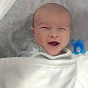 Emerson joined the competition — help win amazing prizes! baby, smiling, blanket, pacifier, infant, bed, sleepwear, head, face, happy, cute, child, newborn, cozy, indoors, resting, wrapped, soft, comfort, sleep