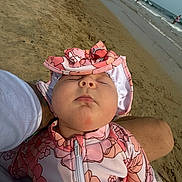 Lilliana joined the competition — help win amazing prizes! baby, infant, sleeping, beach, sand, ocean, waves, sun_hat, pink_outfit, floral_pattern, outdoor, portrait, face, closed_eyes, peaceful, adult_arm, held_baby, shoreline, summer, relaxing