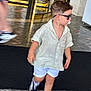 toddler, child, sunglasses, pacifier, shorts, shirt, sneakers, walking, indoor, floor, marble, person, motion_blur, fashion, casual, young_child, cute, hair, legs, adult