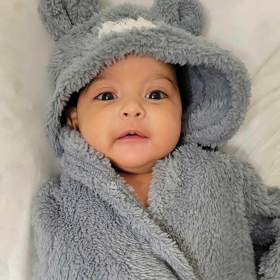Livaï participe au concours pour gagner de l'argent avec cette photo : baby, babywear, blanket, child, closeup, clothing, cute, ears, expression, eyes, face, fluffy, grey, hood, infant, lying, mouth, portrait, soft, warm