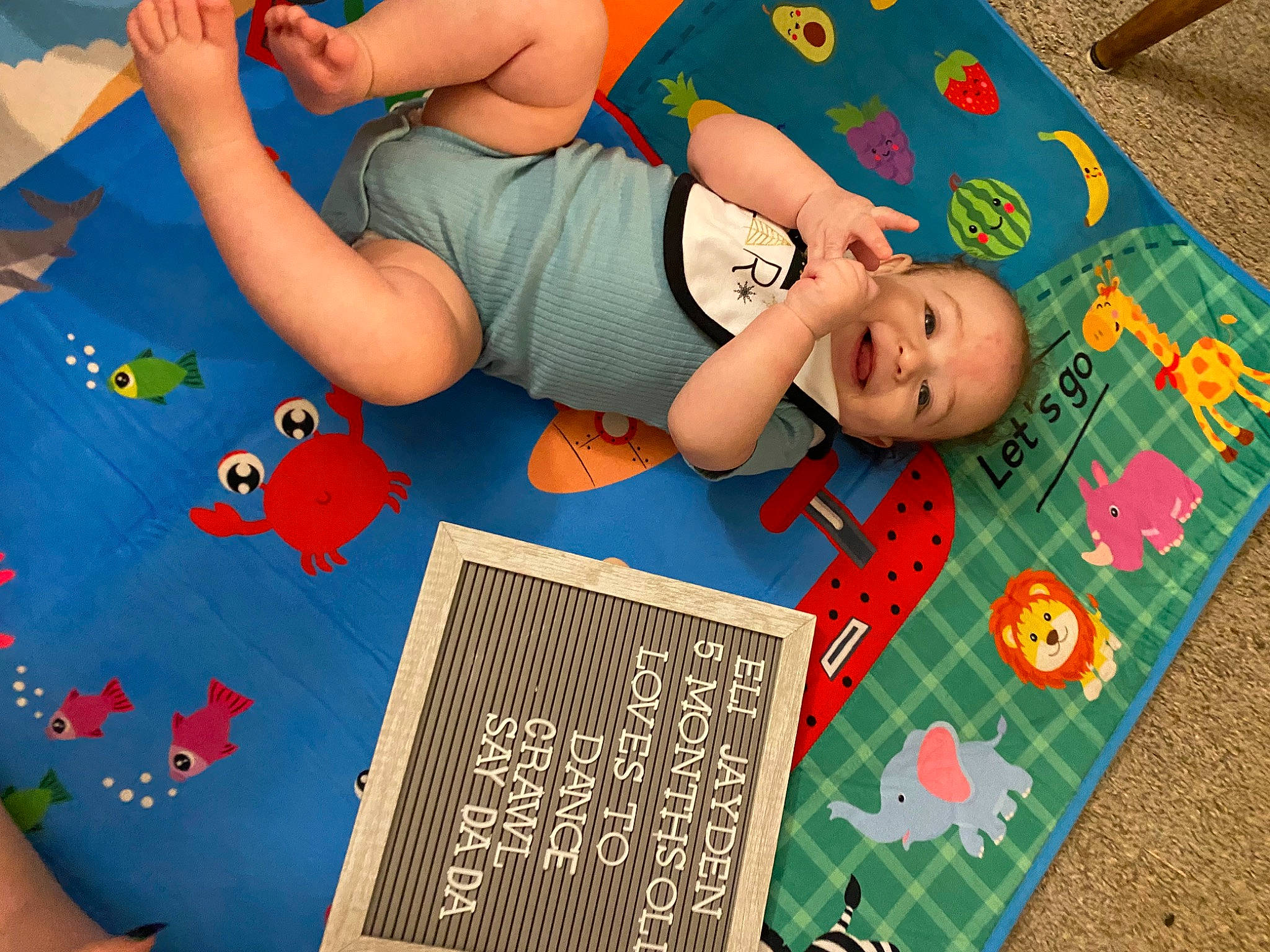 Eli is registered to the contest to win money with this photo: art, baby, baby_toddler_clothing, blue, child, flooring, fun, games, green, happy, leisure, pattern, person, play, red, room, sandal, t_shirt, thigh, toddler