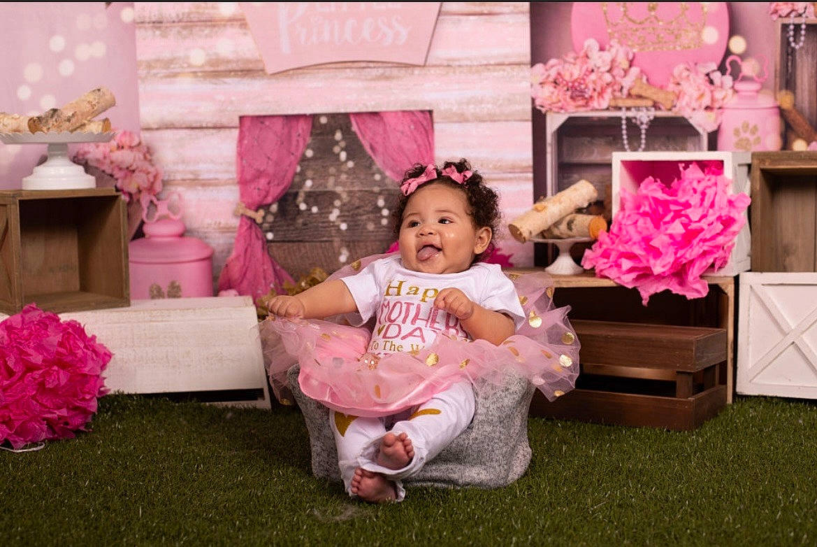Ariah joined the competition — help win amazing prizes! baby, baby_toddler_clothing, child, decoration, event, floral_design, flower, flower_arranging, fun, grass, happy, leisure, magenta, peach, person, petal, pink, plant, room, sitting