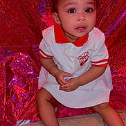 Lauren joined the competition — help win amazing prizes! toddler, child, baby, red_bow, white_dress, red_collar, barefoot, earrings, bracelet, wooden_floor, glittery_background, shiny_backdrop, curious_expression, sitting, indoors, portrait, fashion, cute, young_child, sparkles