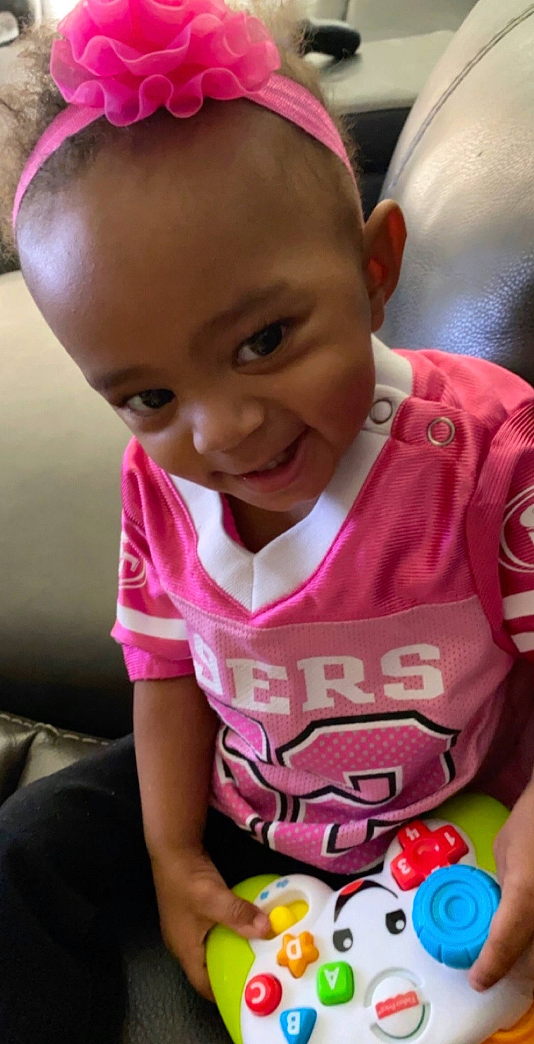 Kynnedi is registered to the contest to win money with this photo: baby_toddler_clothing, cheek, eyelash, face, finger, forehead, hairstyle, hand, happy, head, lip, mouth, neck, nose, person, pink, plant, red, skin, smile