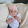 baby, blanket, calvin_klein, child, clothing, cozy, cute, fist, flower, headband, indoors, infant, lying_down, onesie, person, pink, portrait, smiling, soft, young