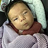 baby, infant, child, portrait, sleepy, pouting, face, car_seat, blanket, knitted_blanket, swaddled, clothing, headrest, indoors, close_up, sitting, cozy, soft_lighting, photography, safe