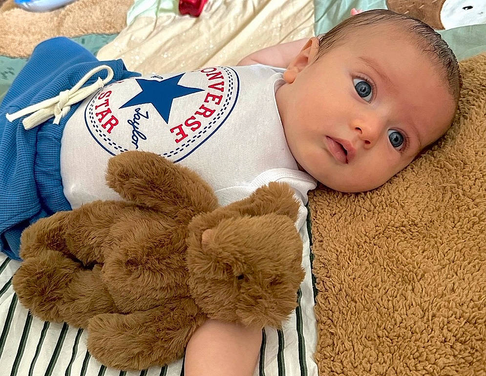 Milo participe au concours pour gagner de l'argent avec cette photo : adorable, baby, bed, blanket, blue_eyes, child, close_up, clothing, comfort, converse, cute, indoor, infant, lying_down, plush_toy, portrait, resting, soft_texture, teddy_bear, young_child