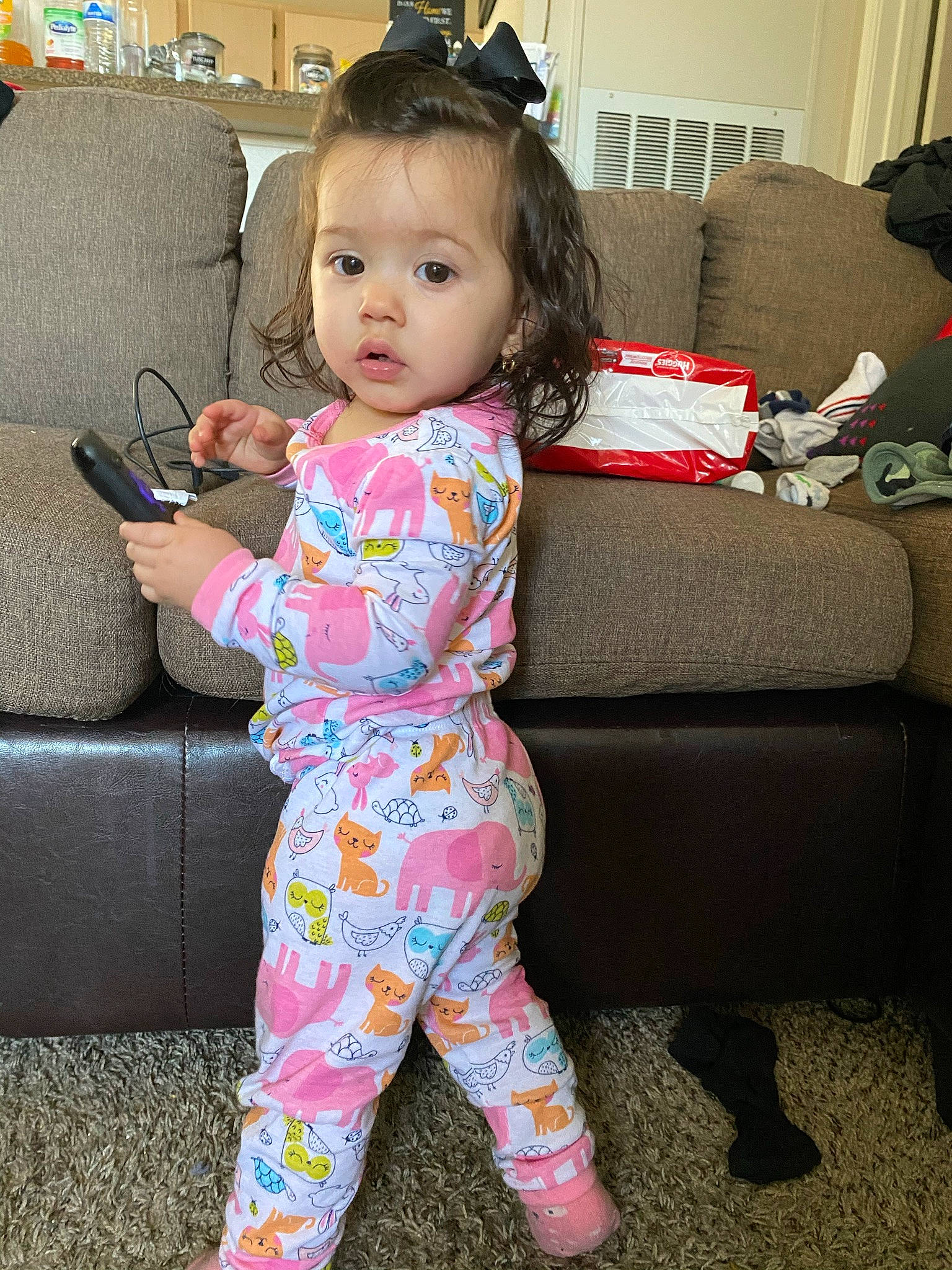 Stella is registered to the contest to win money with this photo: baby, baby_toddler_clothing, cheek, child, comfort, couch, electronic_device, face, hair, happy, head, joint, living_room, person, pink, shoulder, skin, sleeve, standing, thigh