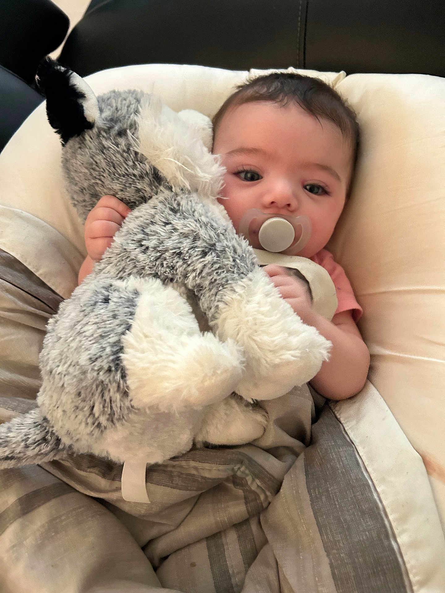 Lilith joined the competition — help win amazing prizes! baby, pacifier, stuffed_animal, blanket, bed, child, infant, cute, soft_toy, sleeping_bag, resting, indoors, comfort, cuddly, face, small_hand, pink_shirt, relaxing, young_child, cozy