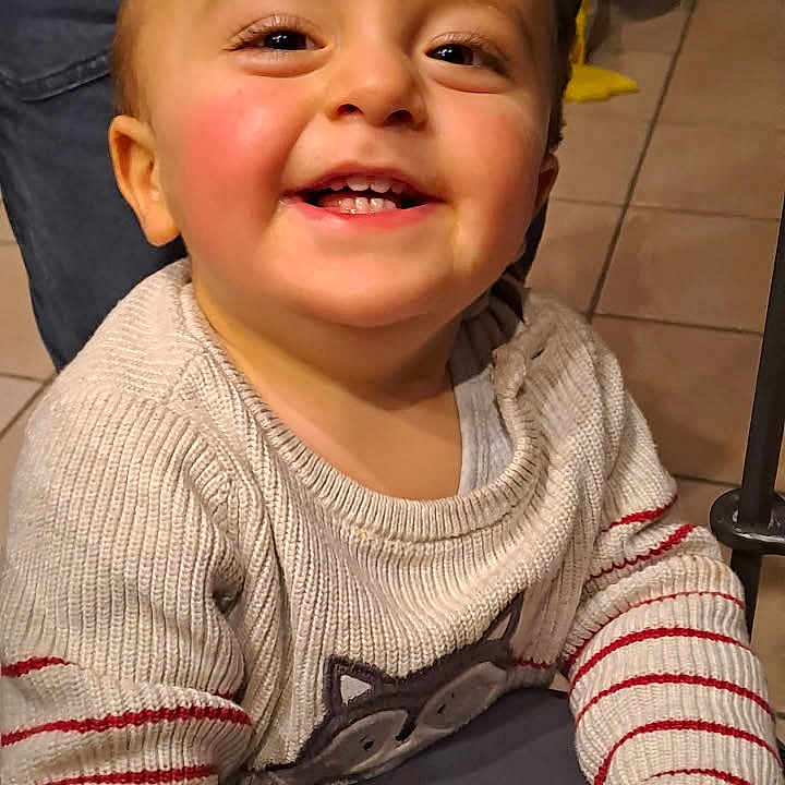 Paolo participe au concours pour gagner de l'argent avec cette photo : animal_design, baby, casual, cheeks, child, clothing, eyes, face, floor_tiles, hand, happy, indoor, joyful, mouth, person, portrait, smiling, striped_sleeves, sweater, toddler