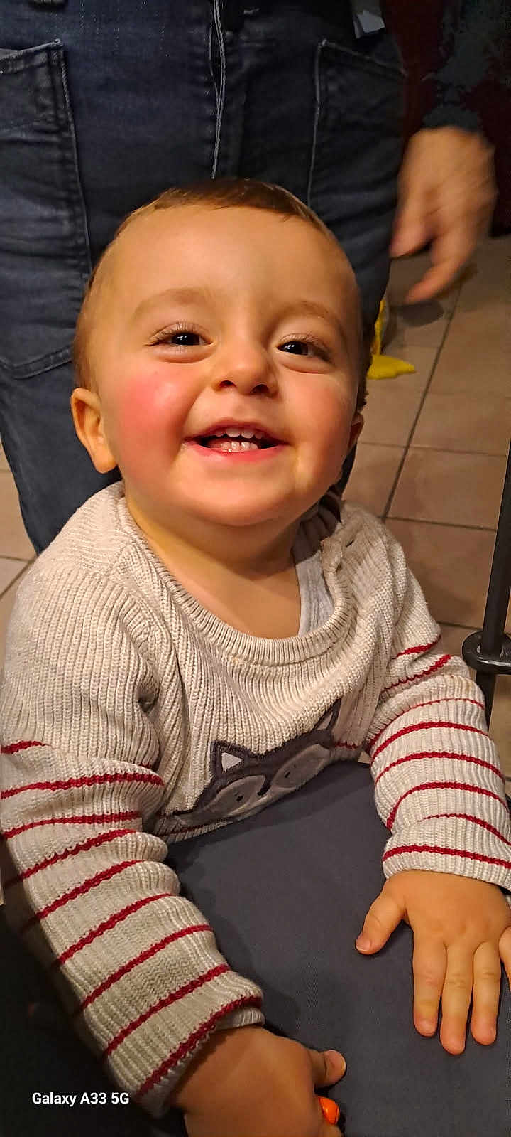 Paolo participe au concours pour gagner de l'argent avec cette photo : toddler, child, smiling, happy, face, sweater, striped_sleeves, animal_design, indoor, floor_tiles, person, hand, cheeks, eyes, mouth, clothing, casual, portrait, baby, joyful