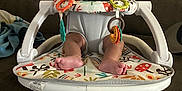 King joined the competition — help win amazing prizes! baby, infant, baby_seat, toys, colorful, couch, indoor, child, curly_hair, feet, face, person, seated, home, play, plastic, fabric, comfort, young, expression