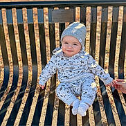 Ayden joined the competition — help win amazing prizes! baby, child, infant, sitting, bench, park, outdoor, autumn, leaves, sunlight, knit_hat, winter_clothing, onesie, socks, smiling, portrait, face, hand, family, playground