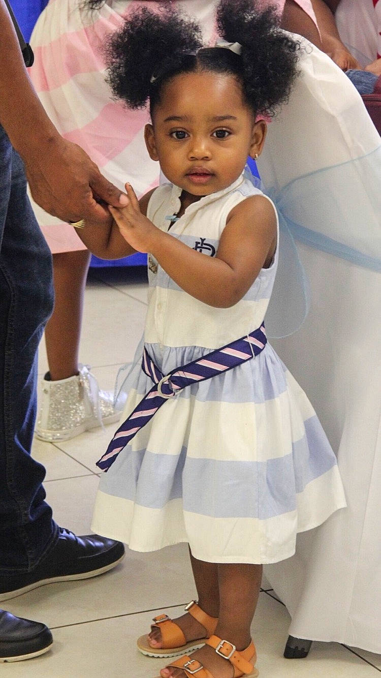 Olivia is registered to the contest to win money with this photo: ceremony, child, child_model, dress, gesture, hair, hairstyle, person, smile, toddler