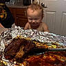 Zayden joined the competition — help win amazing prizes! toddler, child, kitchen, food, ribs, foil, grinning, curly_hair, counter, tray, sauce, meat, indoor, person, door, cabinet, utensil, tablecloth, happy, curious