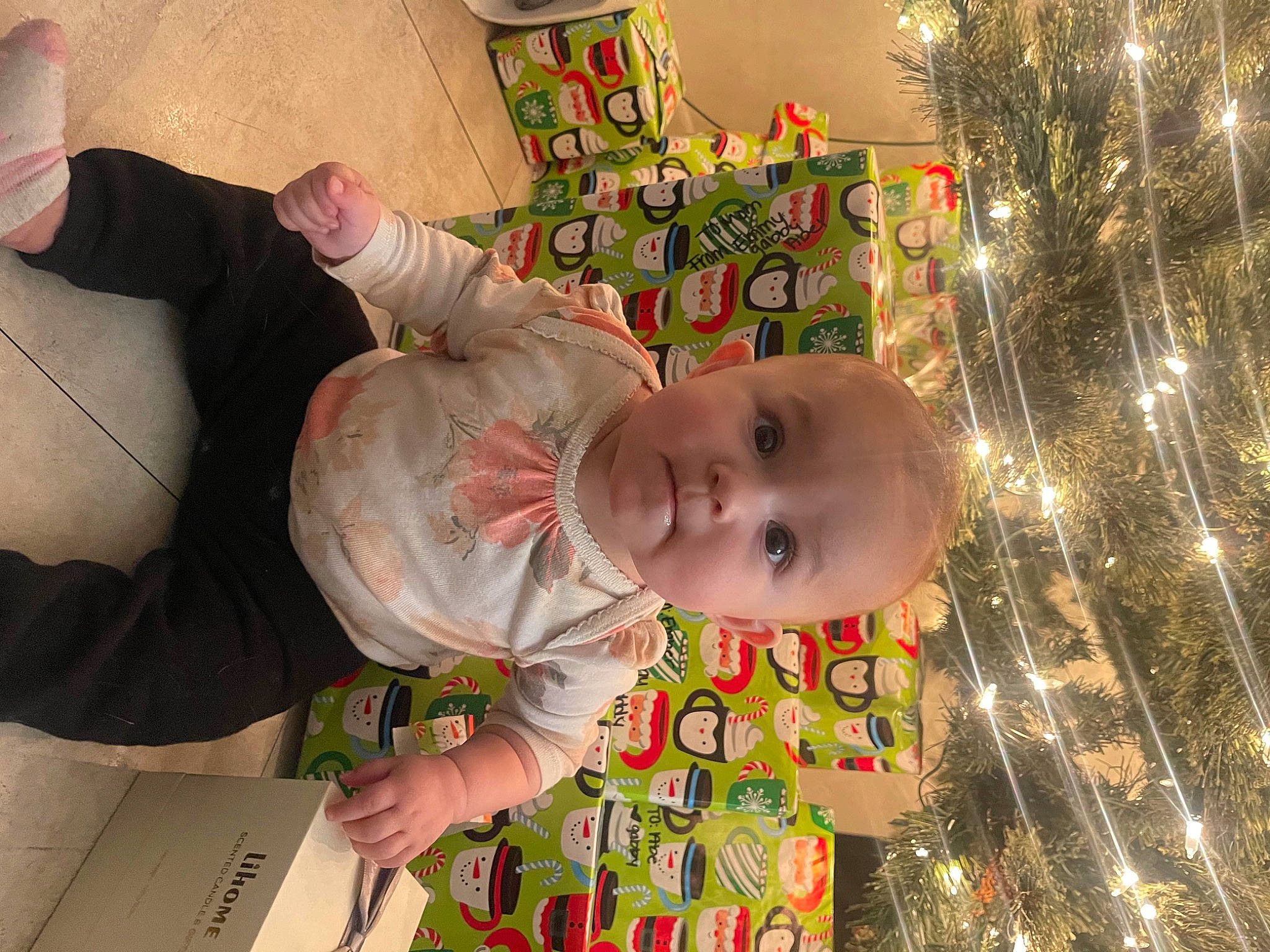 Ember is registered to the contest to win money with this photo: baby, baby_products, baby_toddler_clothing, cheek, child, christmas_decoration, christmas_ornament, christmas_tree, conifer, event, fir, fun, happy, holiday, ornament, person, room, sitting, toddler, tradition