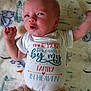 Khaleesi is registered to the contest to win money with this photo: baby, infant, onesie, text, blanket, lying_down, expression, arm, face, clothing, soft, pattern, cute, newborn, pink_pants, indoors, child, skin, portrait, person