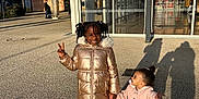 Luna a rejoint le concours — aidez-le/la à gagner de superbes lots ! child, children, outdoor, sunlight, peace_sign, holding_hands, pavement, building, glass, reflection, shadow, coat, jacket, boots, happy, smile, curly_hair, pigtails, toddler, playful