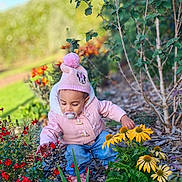 Luna participe au concours pour gagner de l'argent avec cette photo : toddler, child, pink_jacket, minnie_mouse_hat, pacifier, flowers, garden, yellow_flowers, red_flowers, greenery, outdoor, nature, plants, curious, cute, fall_clothing, baby, exploring, sunlight, bokeh_background