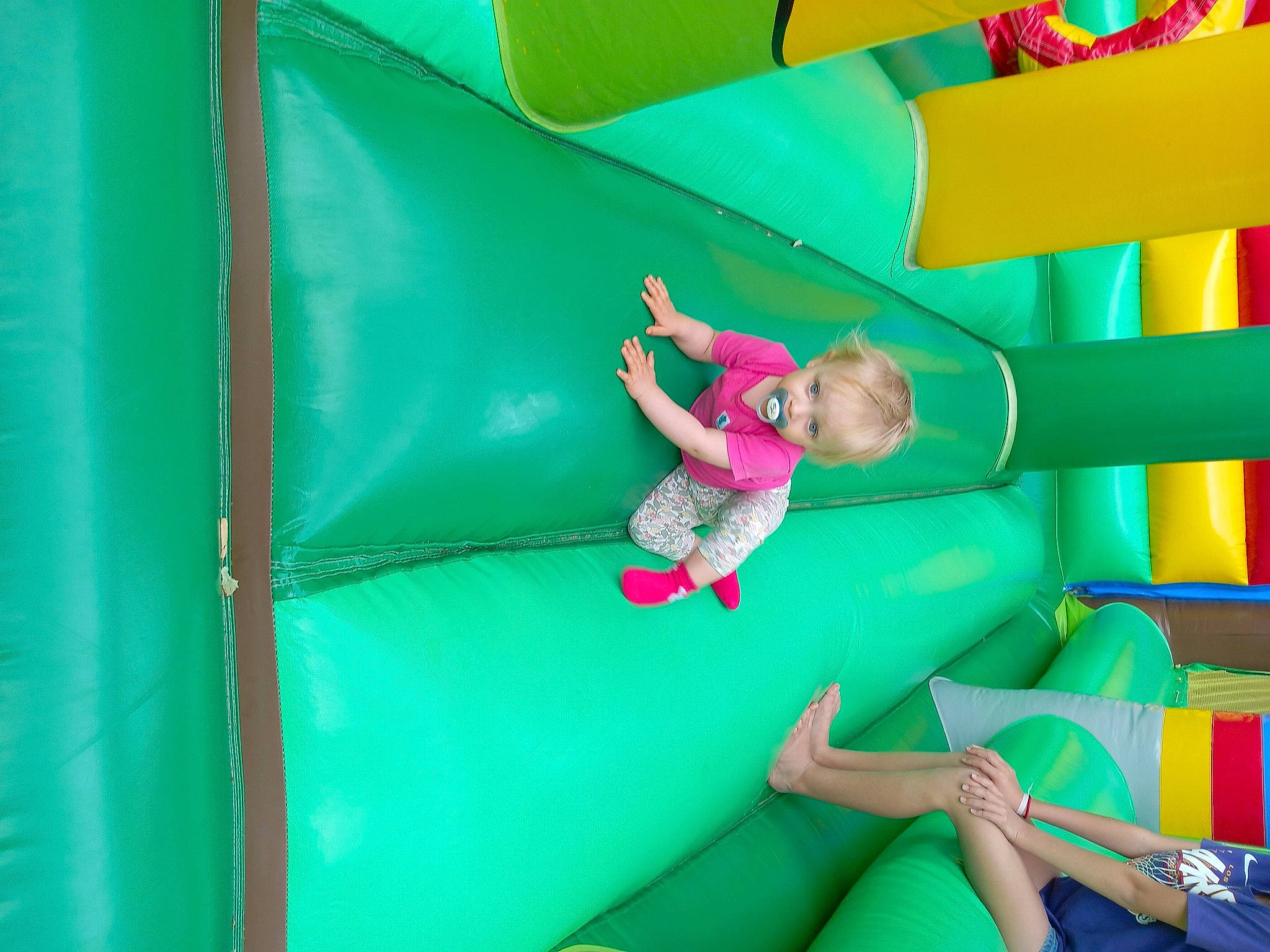 Camille participe au concours pour gagner de l'argent avec cette photo : aqua, bounce_house, child, chute, fun, grass, green, inflatable, leisure, magenta, outdoor_play_equipment, person, play, playground, recreation, room, smile, toddler