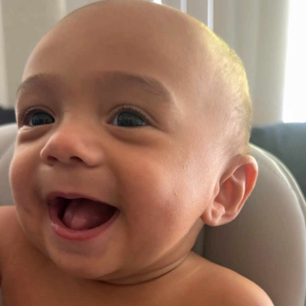 Kruz joined the competition — help win amazing prizes! baby, infant, child, smiling, laughing, face, portrait, close_up, indoor, natural_light, window, high_chair, seated, happy, joyful, bare_shoulders, blue_eyes, open_mouth, home, photography