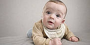 Elio participe au concours pour gagner de l'argent avec cette photo : baby, infant, child, tummy, face, eyes, expression, clothing, beige, blanket, soft_background, portrait, cute, indoors, head_tilt, skin, hands, laying_down, gaze, curious