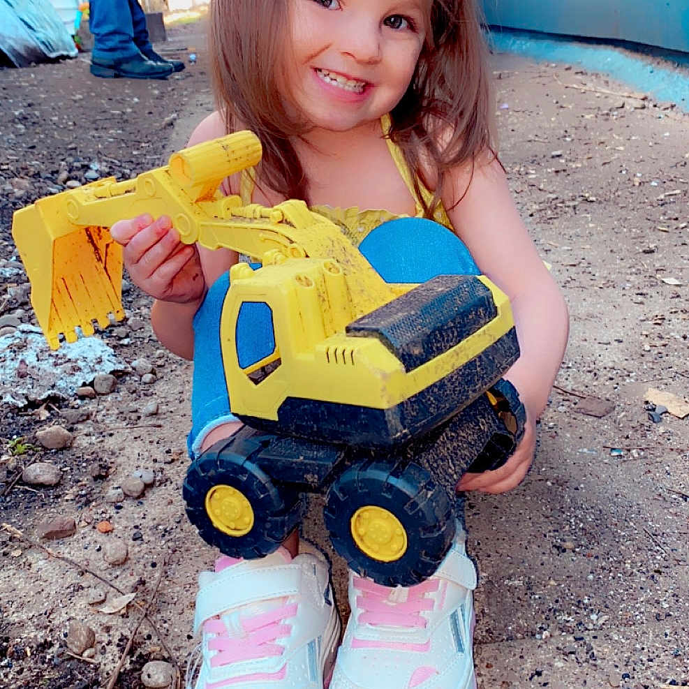 Charlie is registered to the contest to win money with this photo: adult, child, clothing, face, female, footwear, girl, grass, head, machine, male, man, pants, person, photography, plant, portrait, shoe, sneaker, soil