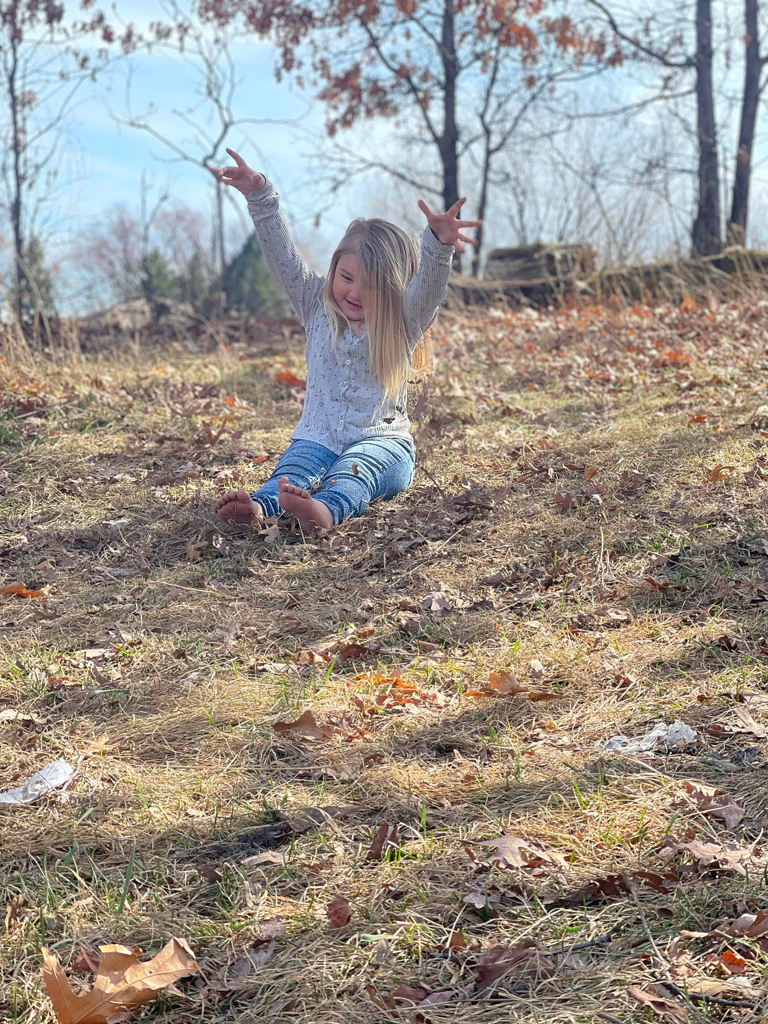 Brooklyn is registered to the contest to win money with this photo: branch, deciduous, ecoregion, forest, grass, grassland, happy, landscape, natural_landscape, people_in_nature, person, plant, sky, soil, toddler, tree, trunk, twig, wood, woodland