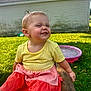 toddler, child, outdoor, grass, bench, yellow_shirt, coral_shorts, pink_pool, shed, smiling, happy, playful, sunlight, grass_lawn, wood, person, cute, expression, summer, daytime