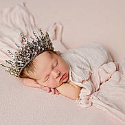 Leila joined the competition — help win amazing prizes! newborn, baby, sleeping, crown, infant, soft_fabric, pastel_colors, wrapped, portrait, peaceful, cute, head, face, resting, delicate, closeup, indoors, blanket, skin, tiny_hands