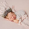 newborn, baby, sleeping, crown, infant, soft_fabric, pastel_colors, wrapped, portrait, peaceful, cute, head, face, resting, delicate, closeup, indoors, blanket, skin, tiny_hands