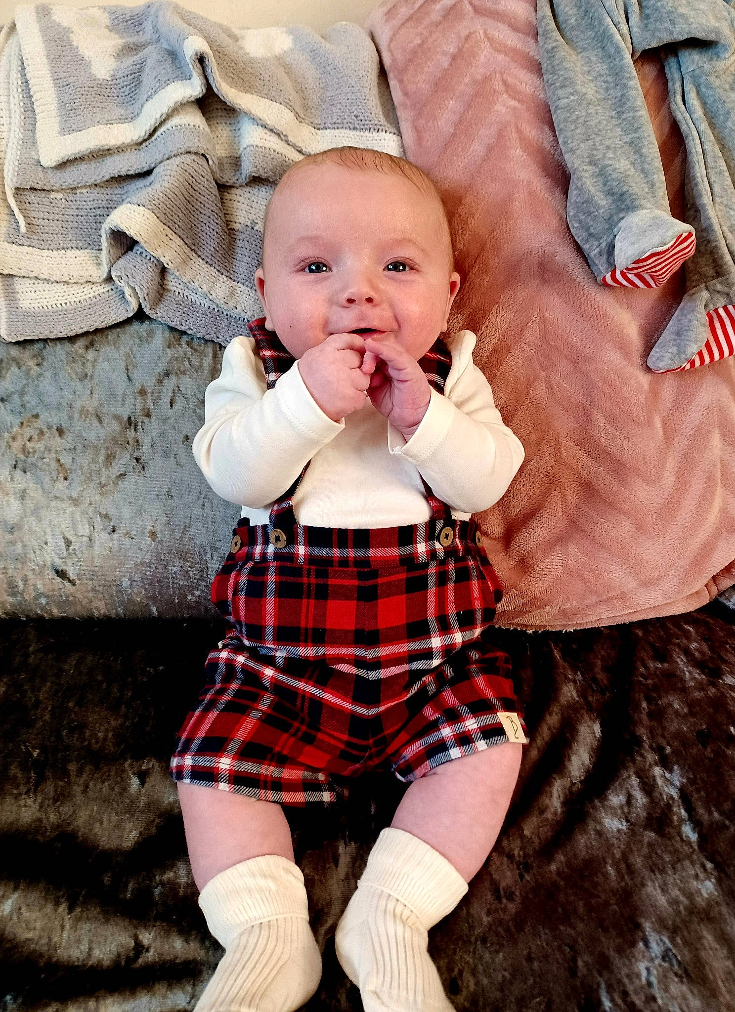 Archie is registered to the contest to win money with this photo: arm, baby_toddler_clothing, collar, eye, face, finger, hairstyle, hand, happy, head, human, human_body, leg, outerwear, person, plaid, skin, sleeve, tartan, textile