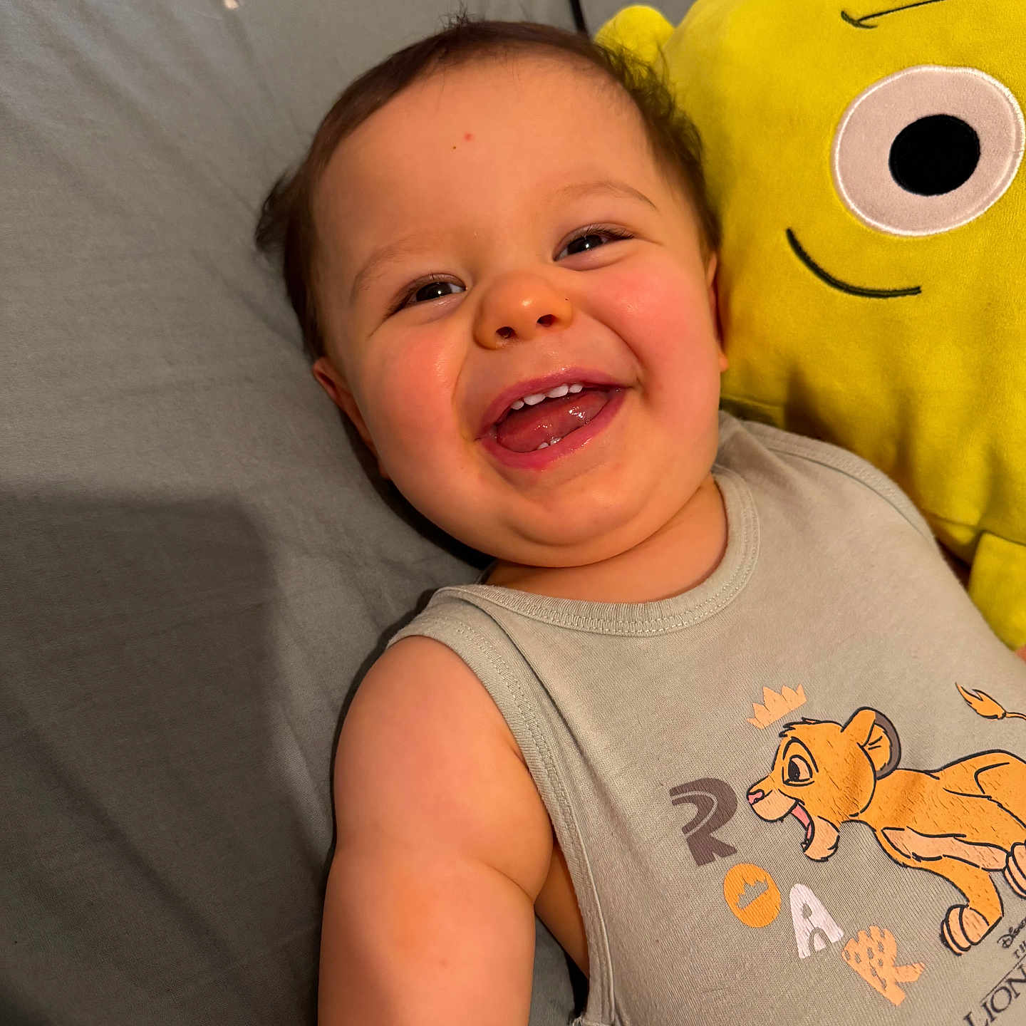 Léo participe au concours pour gagner de l'argent avec cette photo : baby, bed, cartoon, child, childhood, clothing, cute, face, happy, indoors, infant, lion_king, person, plush_toy, portrait, sleeping_area, sleeveless_shirt, smiling, toy, yellow