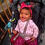 Skyler joined the competition — help win amazing prizes! baby, child, stroller, pink_headband, happy, smiling, harness, outdoor, toy, patterned_clothing, pink_shirt, pink_pants, heart_pattern, infant, seatbelt, baby_girl, cute, sitting, playful, colorful