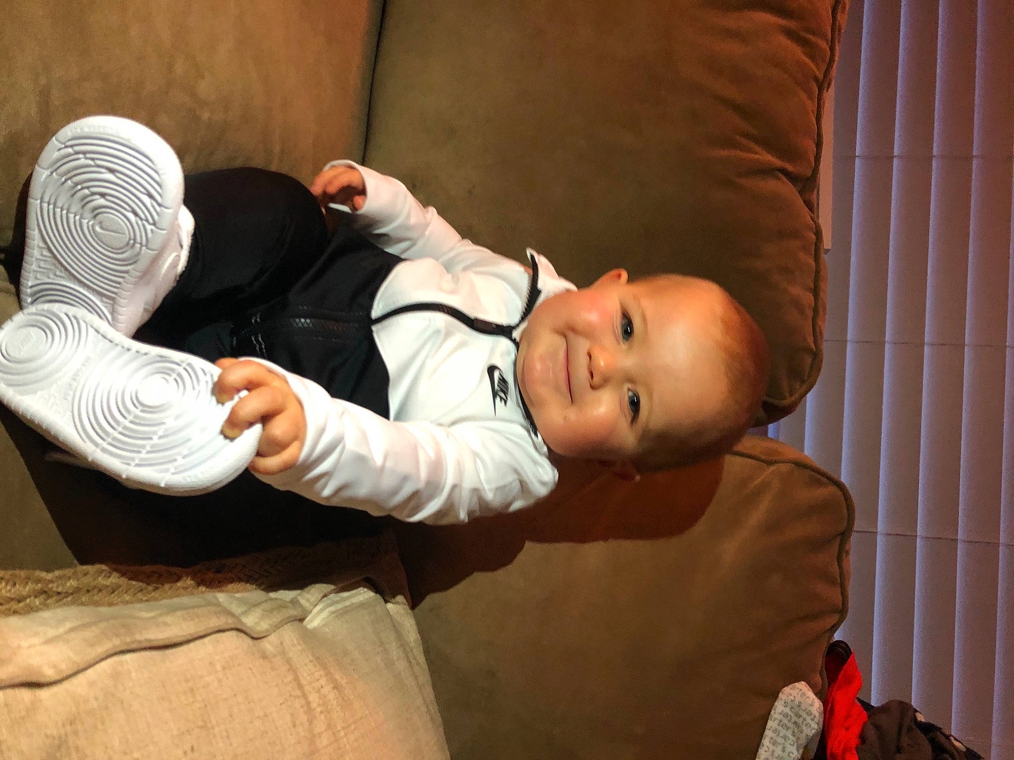 Kian is registered to the contest to win money with this photo: baby, baby_toddler_clothing, child, comfort, elbow, flash_photography, foot, fun, gesture, happy, head, human_body, human_leg, joy, person, room, sitting, smile, thumb, toddler