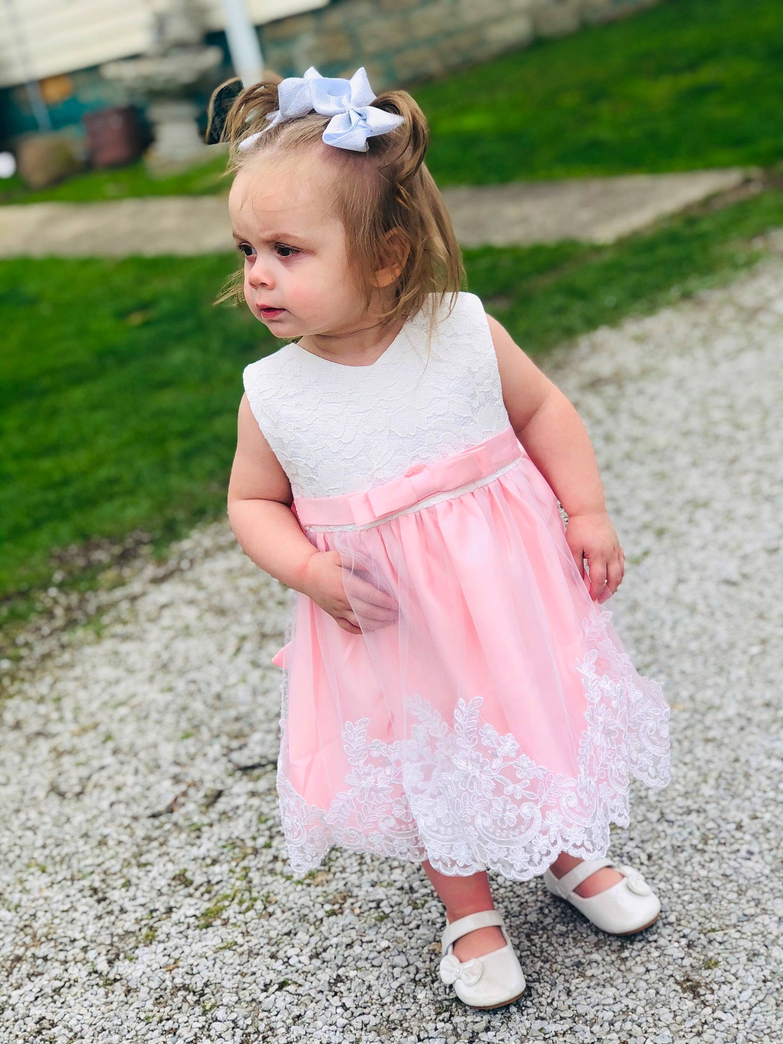 Teagyn is registered to the contest to win money with this photo: baby, baby_toddler_clothing, ceremony, child, child_model, clothing, dress, fashion_accessory, flower, grass, hair_accessory, headband, headpiece, pattern, person, petal, photography, pink, play, toddler