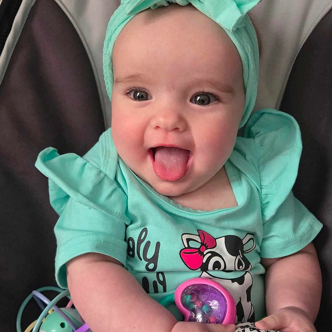 Sadie joined the competition — help win amazing prizes! baby, babylaughing, bodypart, clothing, coat, face, happy, head, hood, jacket, mouth, person, photography, portrait, stroller, t_shirt, tongue, yawning