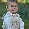 Elio a rejoint le concours — aidez-le/la à gagner de superbes lots ! toddler, child, smiling, outdoor, grass, vest, bow_tie, flower, daisy, portrait, cute, happy, young_child, nature, greenery, casual, sitting, face, person, fashion