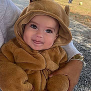 Elio a rejoint le concours — aidez-le/la à gagner de superbes lots ! baby, child, costume, bear, cute, outdoor, smile, tongue, playful, person, hands, holding, fuzzy, hood, nature, grass, stone_wall, sunlight, casual, daytime