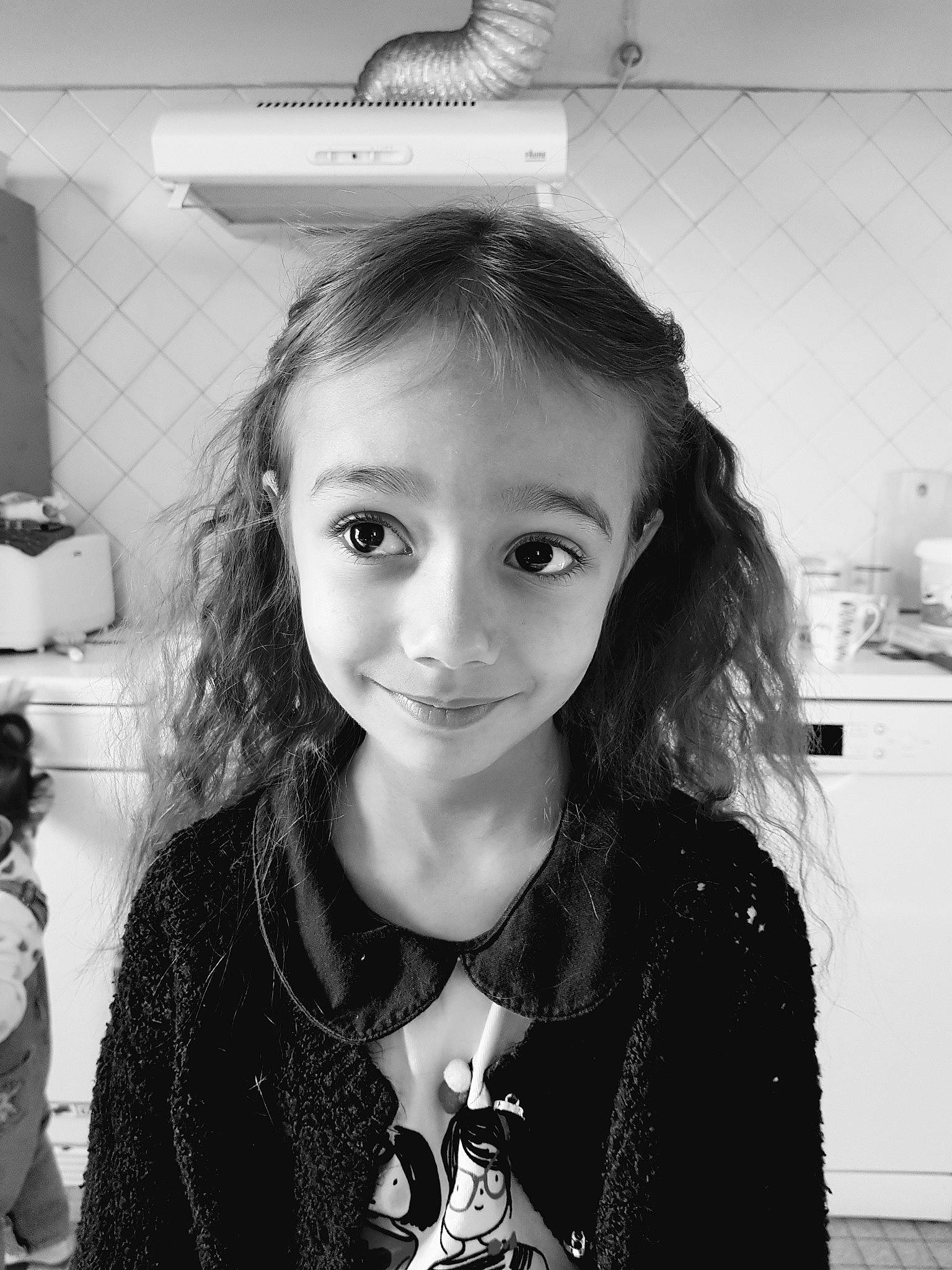 Eliséa participe au concours pour gagner de l'argent avec cette photo : black, black_and_white, clothing, eyebrow, flash_photography, hairstyle, happy, iris, jaw, joy, lip, neck, organ, outerwear, person, photograph, sleeve, smile, standing, style