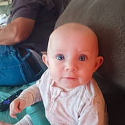 Patilyn is registered to the contest to win money with this photo: baby, child, toy, couch, person, indoor, clothing, face, hand, sitting, adult, background, curious, play, expression, furniture, blue_jeans, long_hair, home, casual